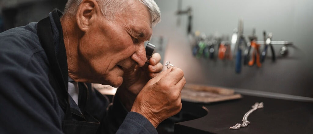 1. Expert jeweler examining a lab-grown diamond with a loupe in a workshop.